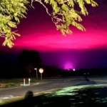 Cannabisfarmens odlingslampor gör himlen över en liten australisk stad ljusrosa